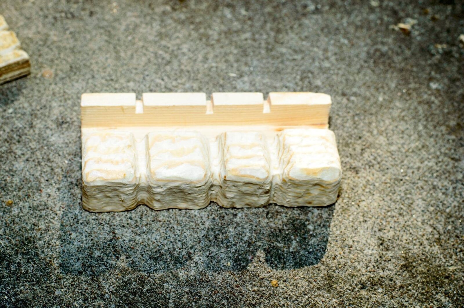 Carved wood offcut forming four large stones for the bottom of the door