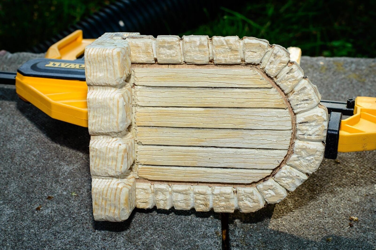 Assembled wooden faerie door and stone frame held in clamps