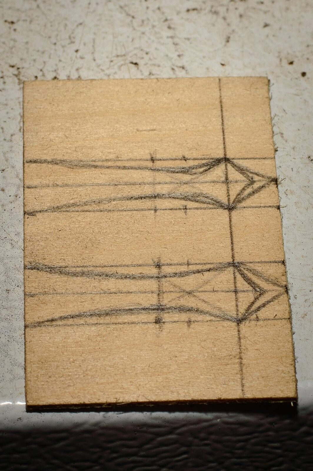 Two pointed hinge straps drawn on thin basswood before carving