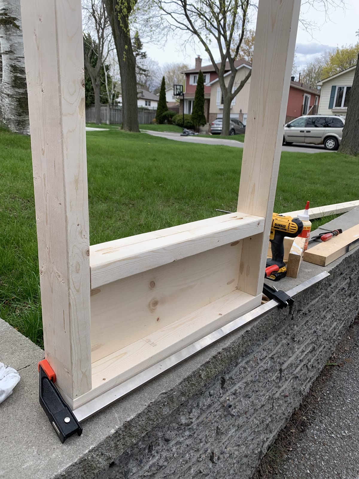 Lower wooden frame assembled with clamps, glue and a drill nearby