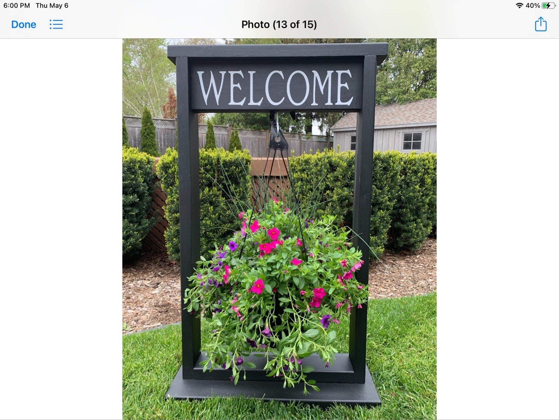 Inspiration photo of a black welcome sign frame with a hanging flower basket